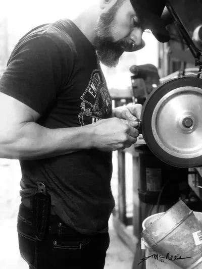 Jonathan McNees grinding a blade in Vernon, Alabama
